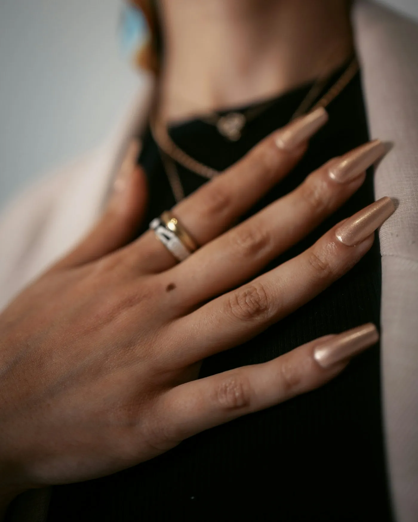 Long champagne-gold nails with gold rings